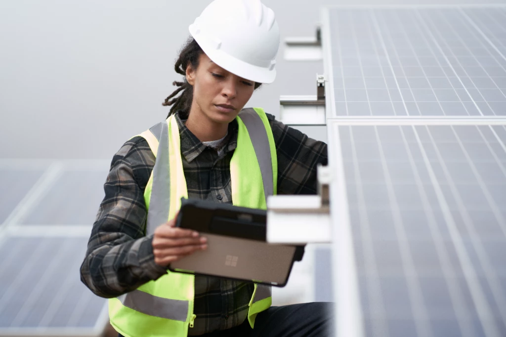 Person with tablet next to solar panels
