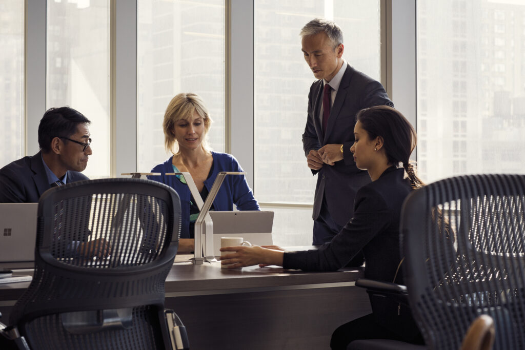 Men and women in in open workspace in office