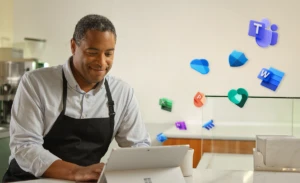 A small business owner sitting at a table using Microsoft 365 on a laptop computer