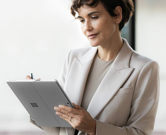 Woman in a blazer using a Microsoft Surface tablet.