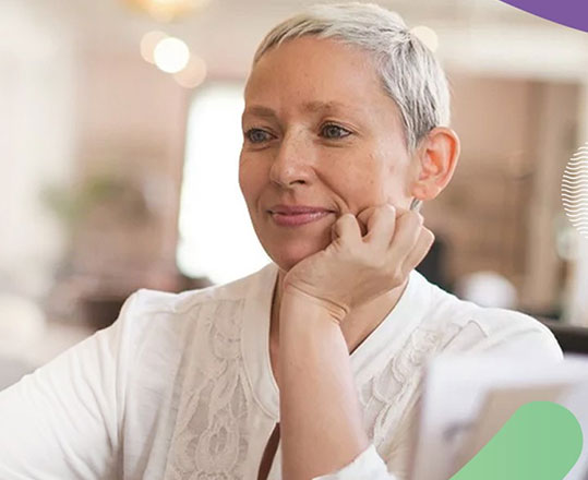 Woman with short gray hair looking at a computer screen.