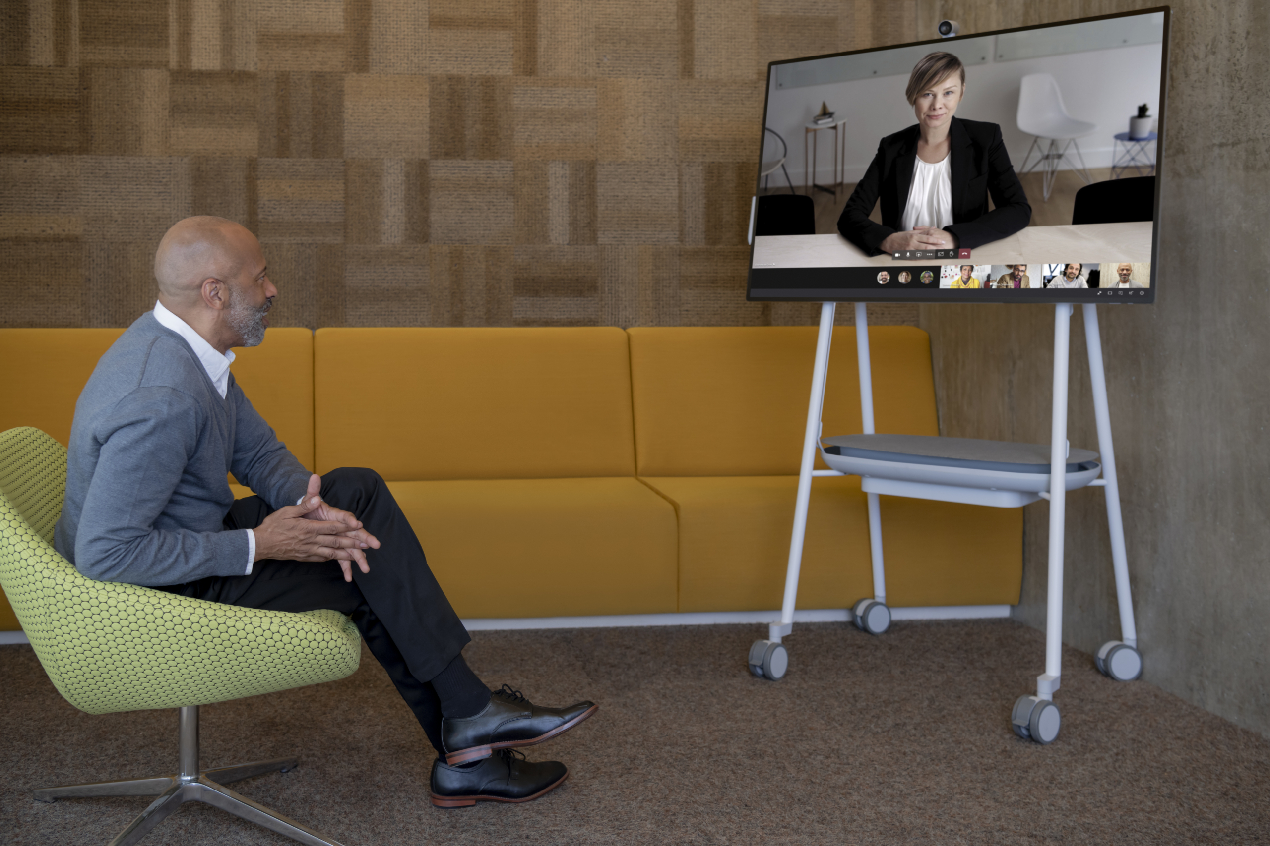 Adult male in his office collaborating with a woman via Microsoft Teams on a Surface Hub 2S 50” device. Expires 11/25/2022