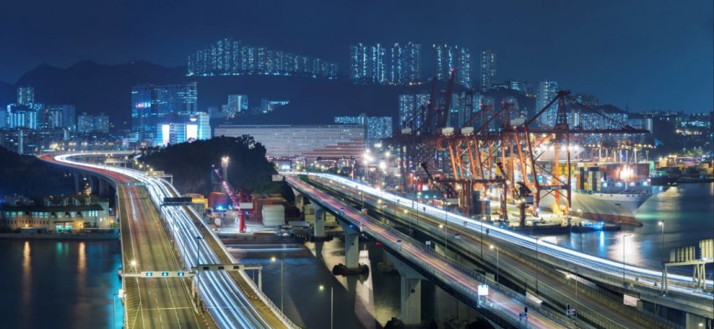Image of traffic, cranes, and buildings.