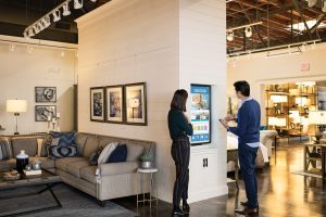Two people using device in retail store