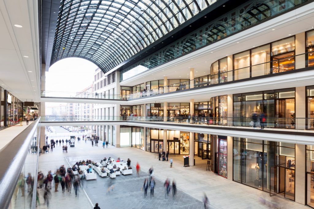 Modern Shopping Mall with stores, cafe and shoppers walking around
