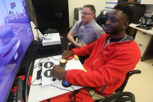 Man works with veteran with the XBOX Adaptive Controller