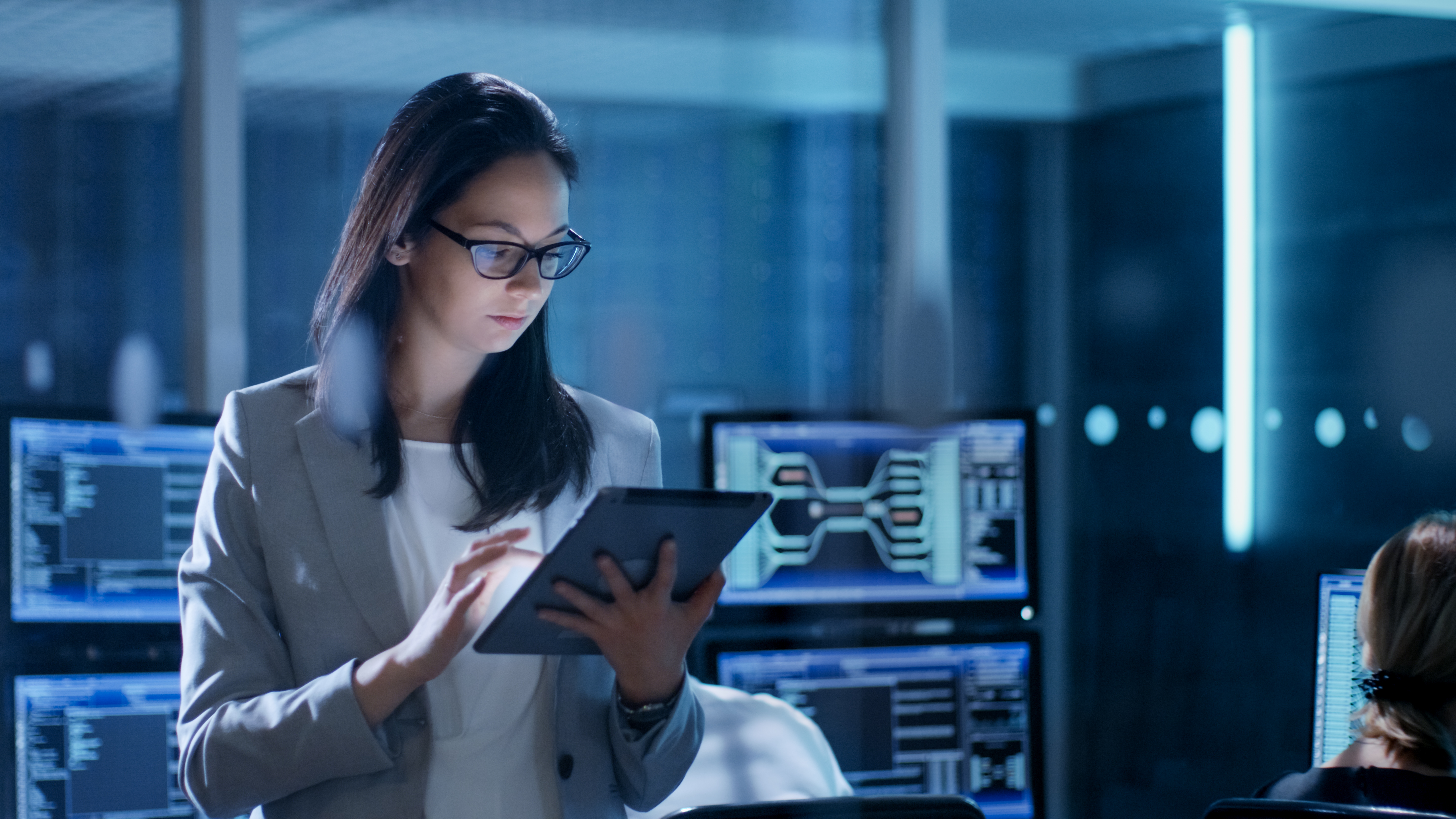 Female government employee uses tablet in system control center.