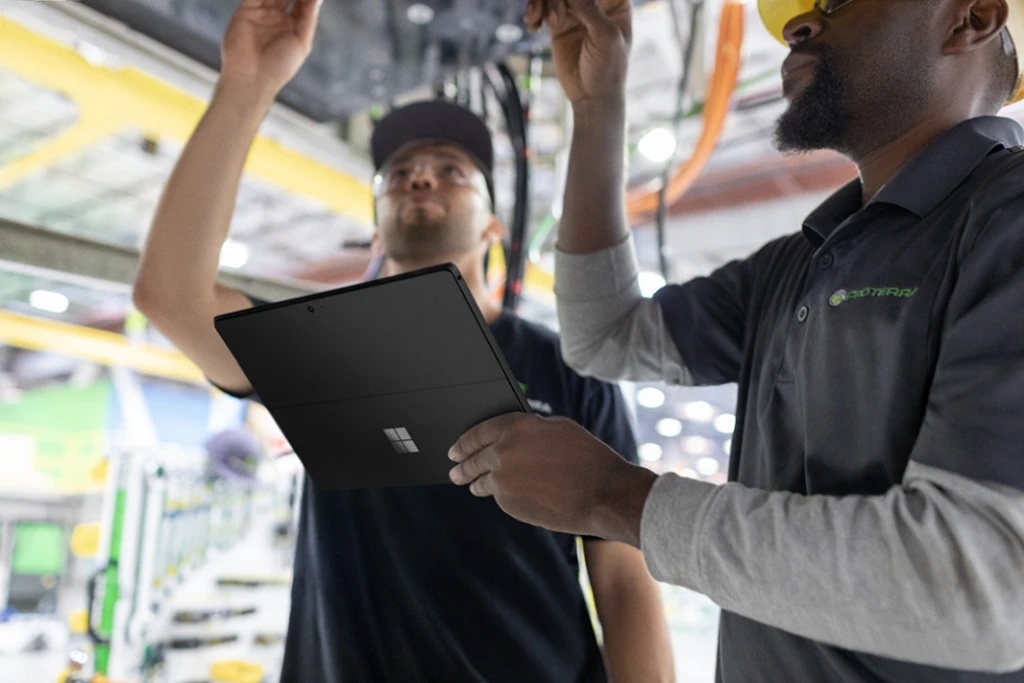 two people looking at computer parts holding a tablet