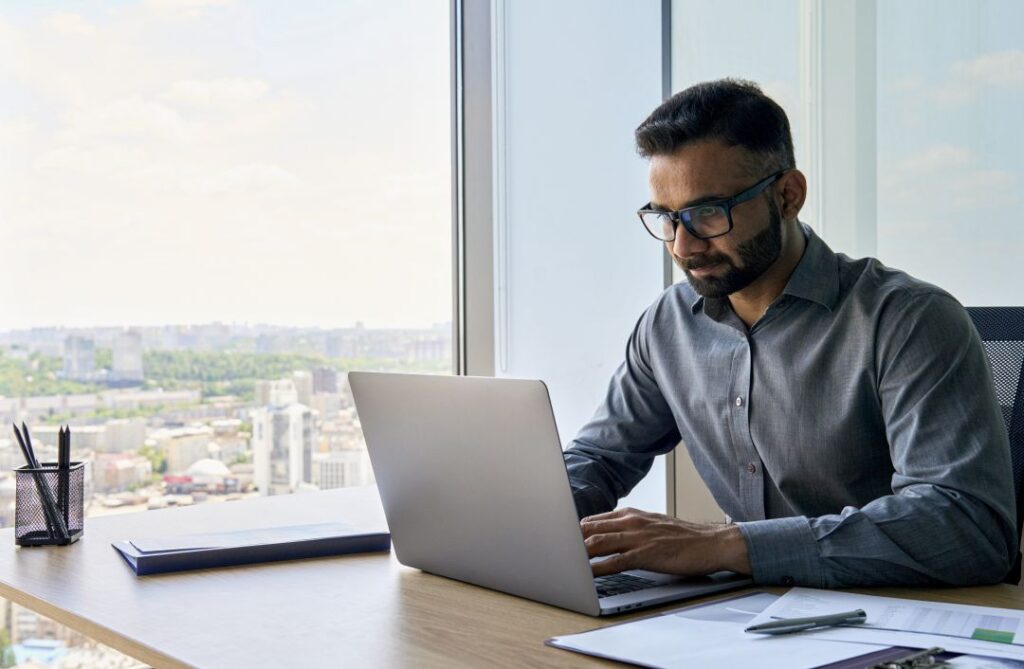 A man sitting at a desk with a laptop