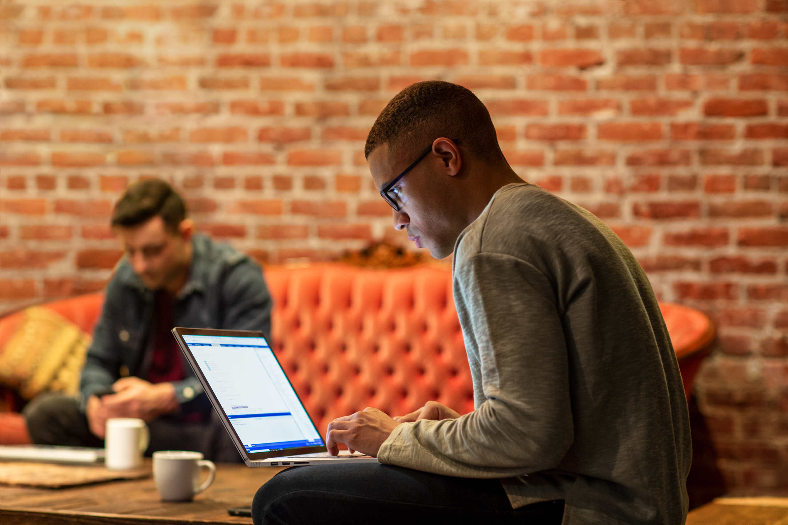 Male developers work remotely from a café.