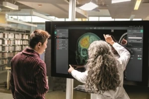 A doctor and developer in front of an fMRI brain image. Responsible AI is important in the medical industry