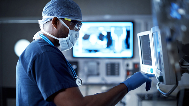 Doctor with protective gear working on healthcare technology