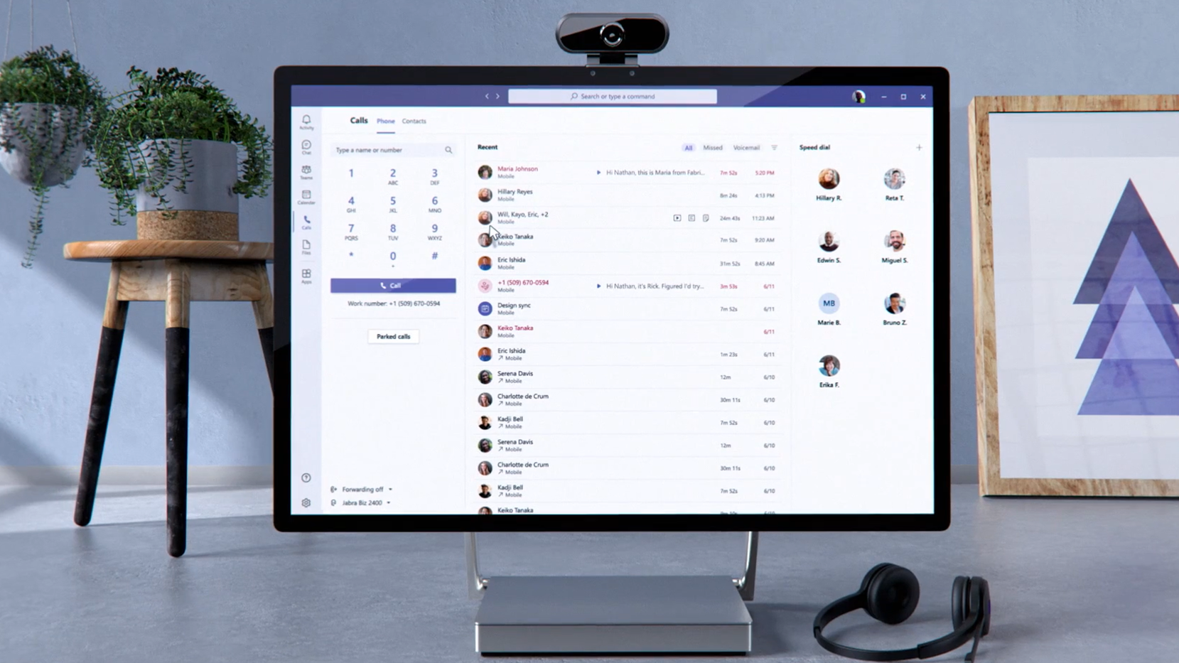 Desktop with Teams UI, headset keyboard, mouse, and speaker puck.