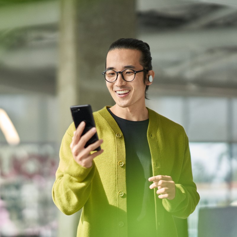 A man collaborating with others during a Microsoft Teams meeting while on the go.