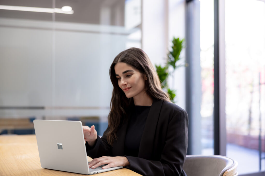 A woman sitting at a table using a laptop