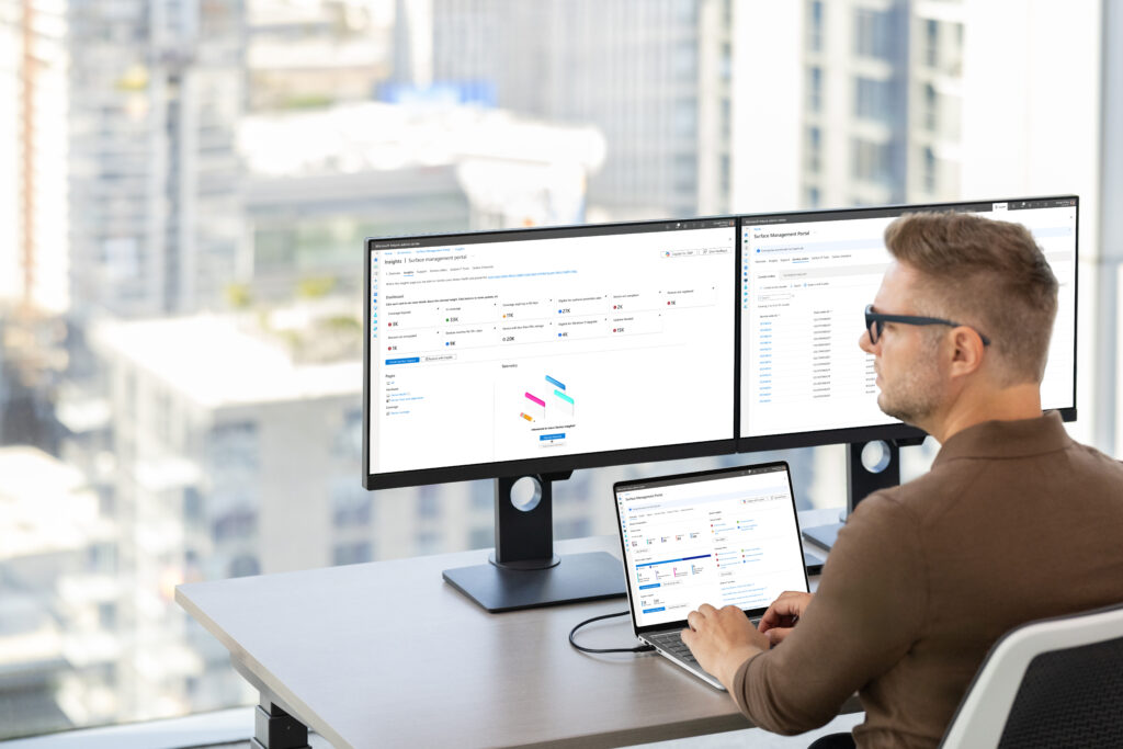 A man sitting at a desk with two computers