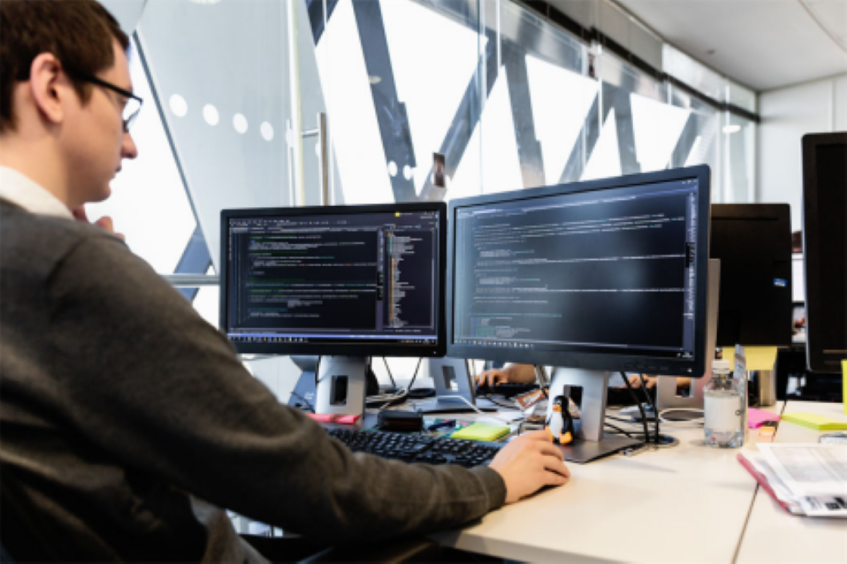 Man looking at two screens