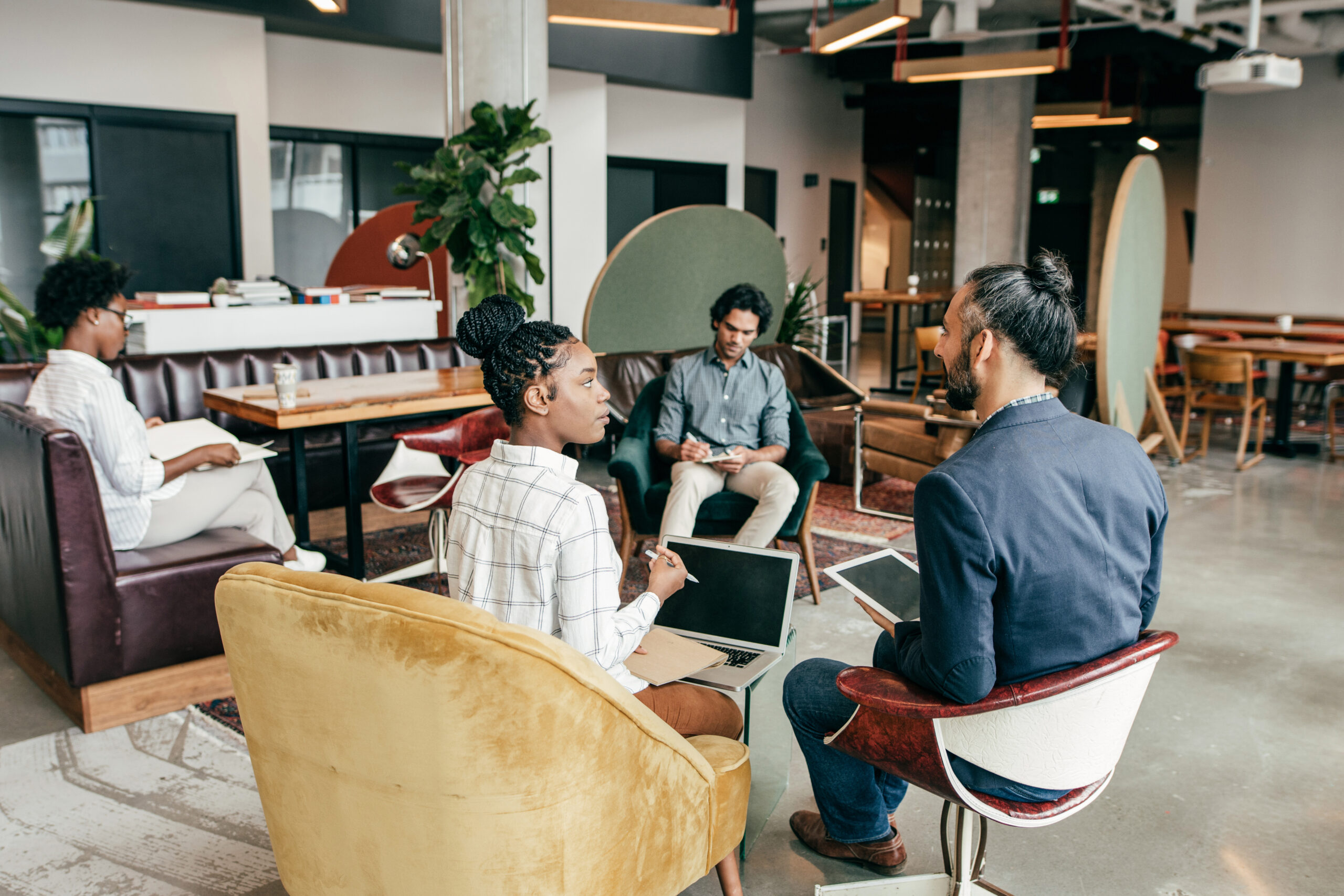 A group of people sitting in chairs and talking