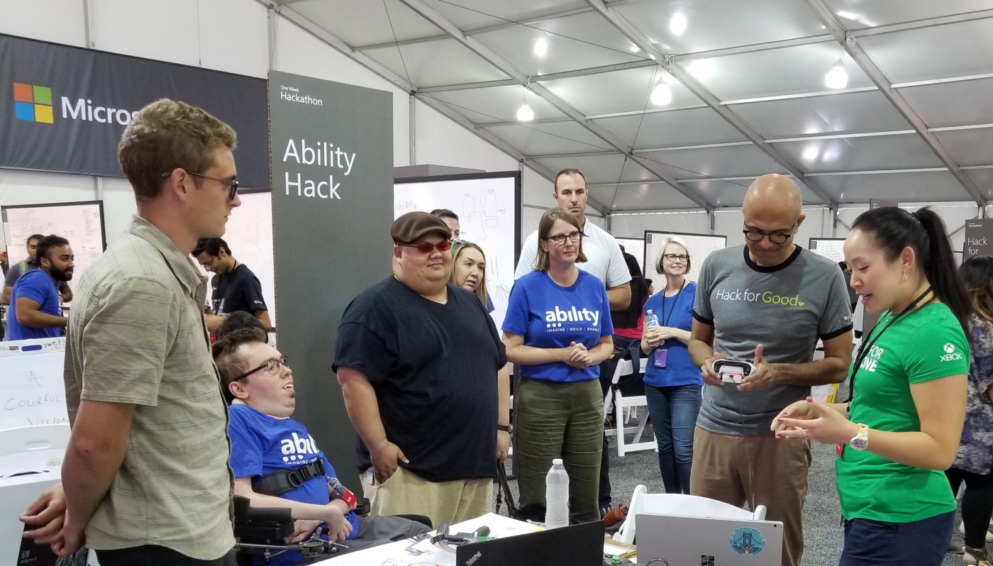 A group of six team members looks at the controller