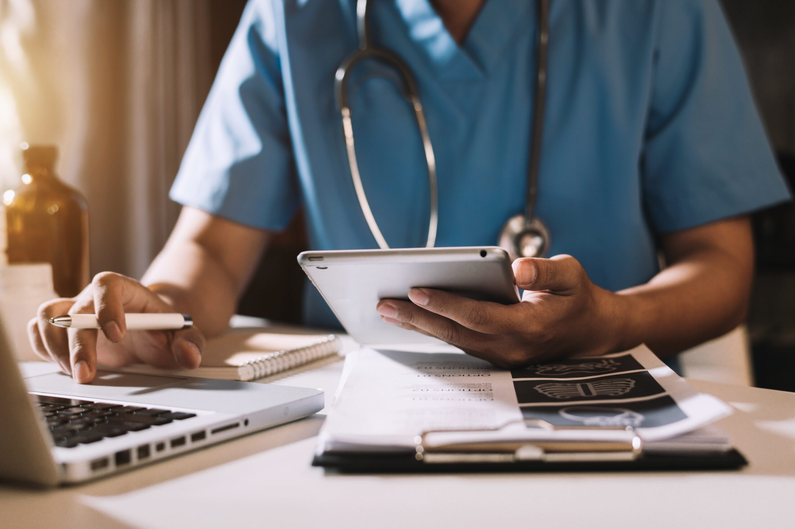 Doctor working with mobile phone and laptop