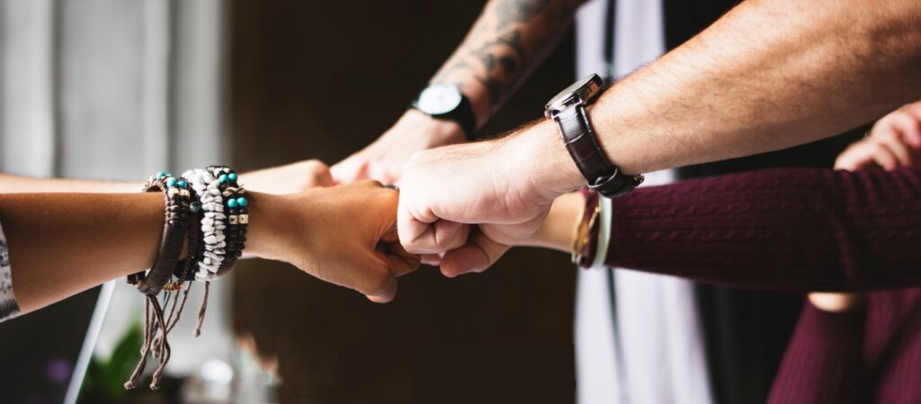 group of people fist-bumping each other