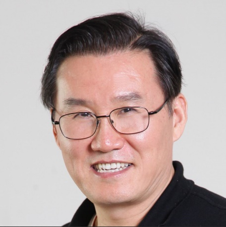 a man wearing glasses and smiling at the camera