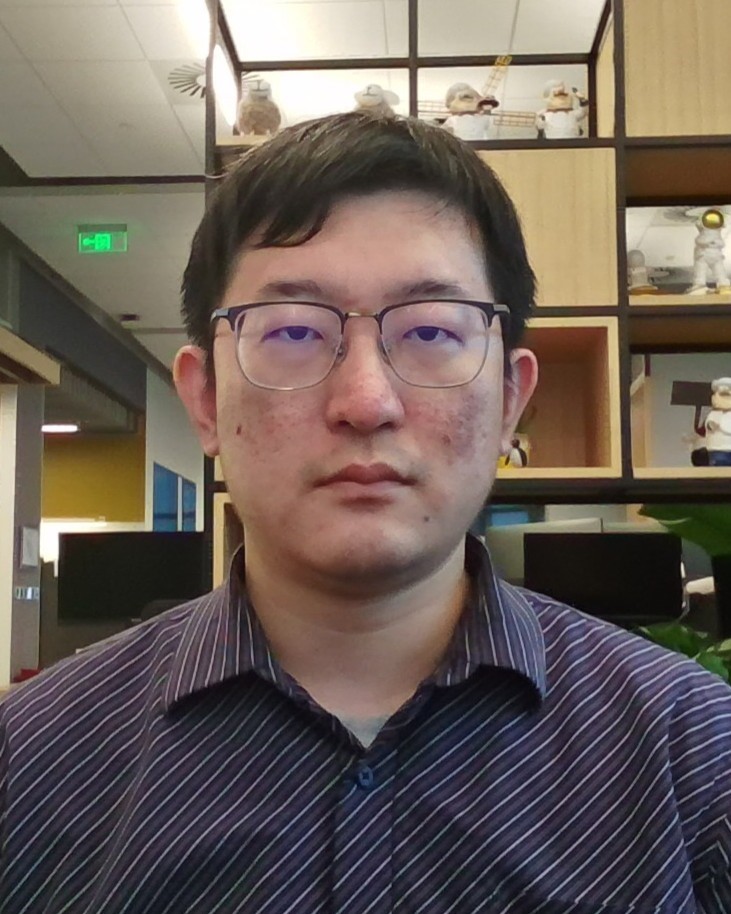 a man wearing glasses and smiling at the camera