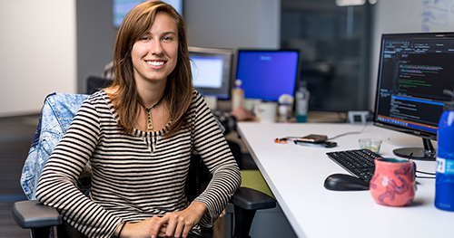 An image of a woman sitting at a PC work station.