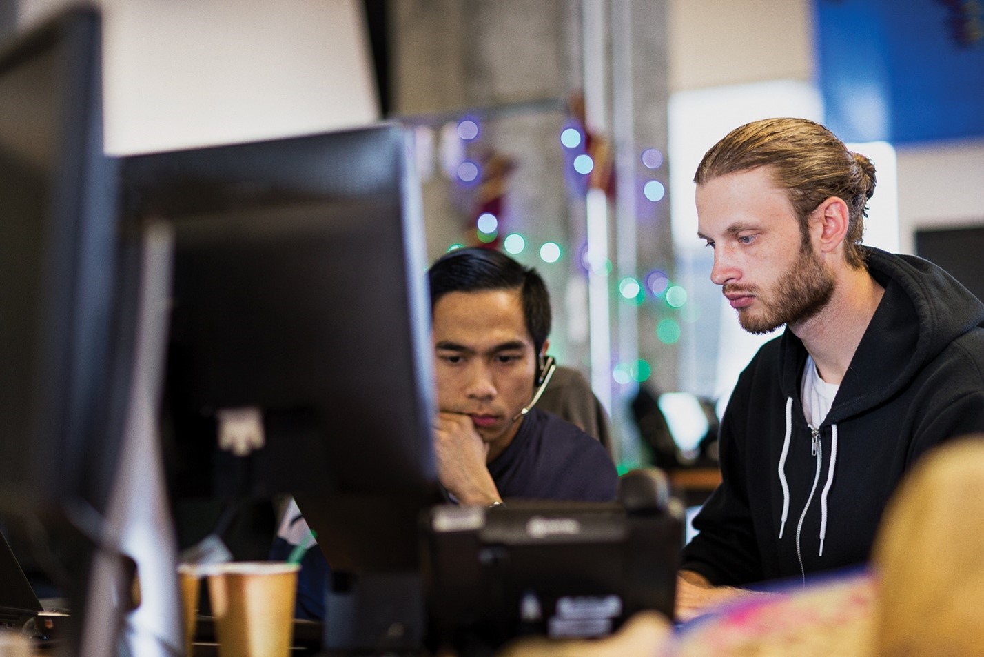 Two adults collaborating at a work station.