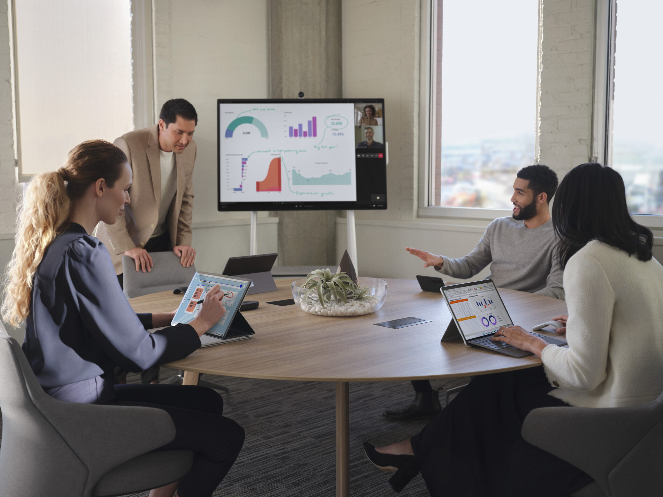 Group of four men and women having a meeting around a table in a conference room.