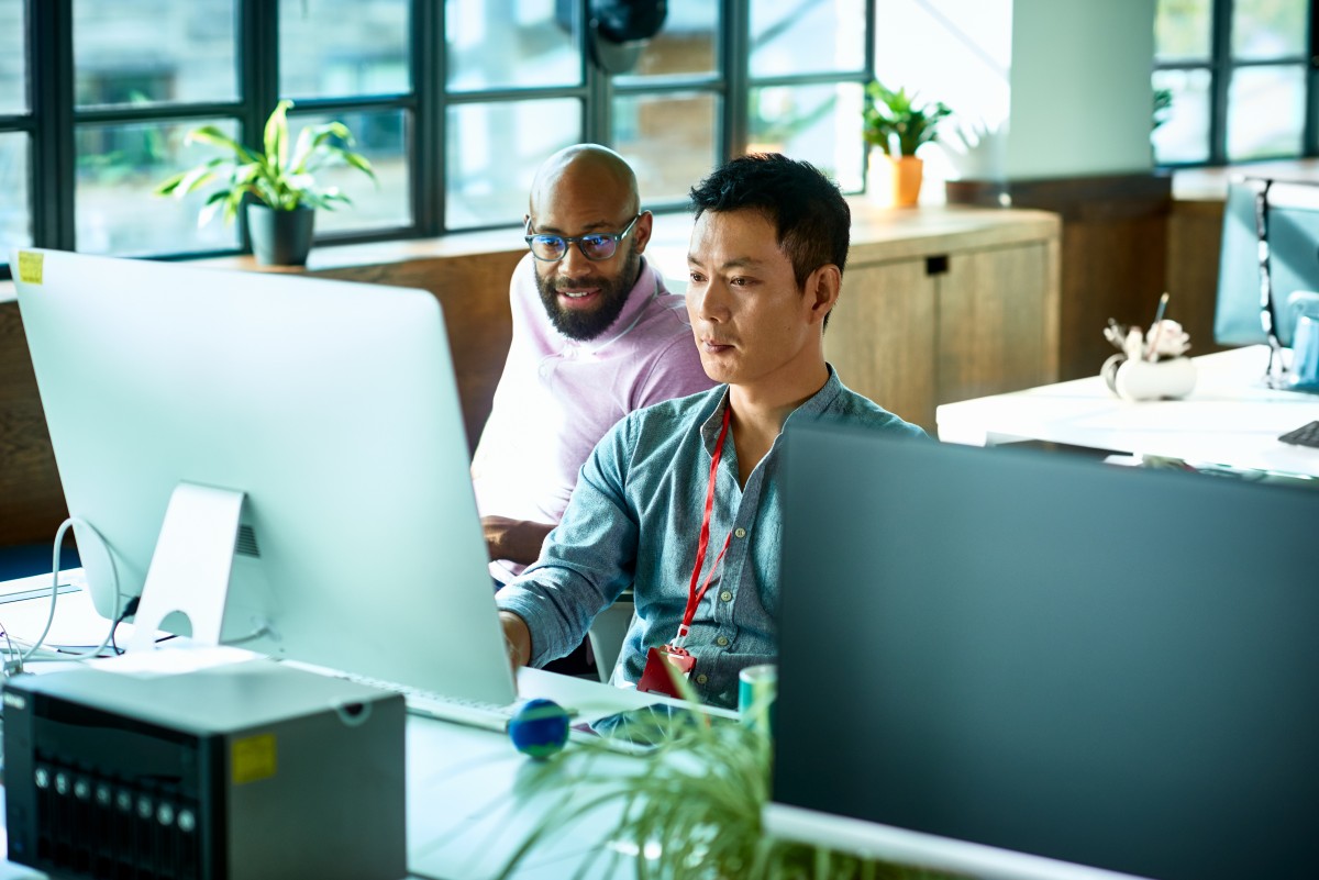 A group of men looking at a computer