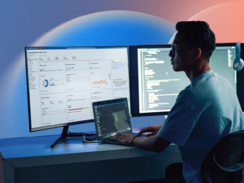 A man sitting at a desk with two computer screens