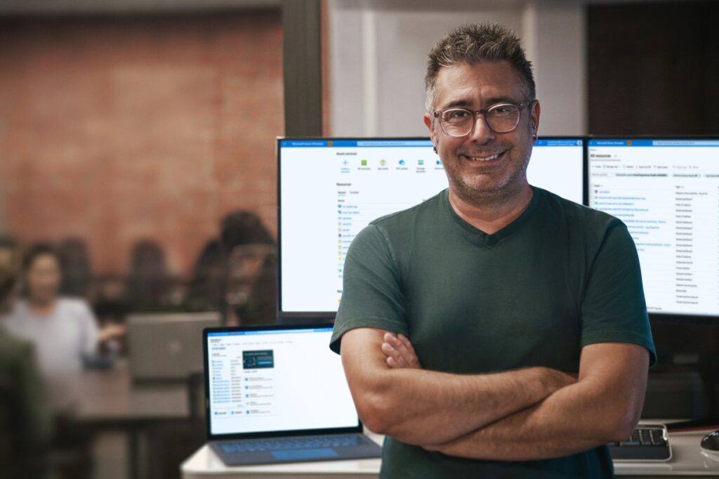 man standing in front of computer screens
