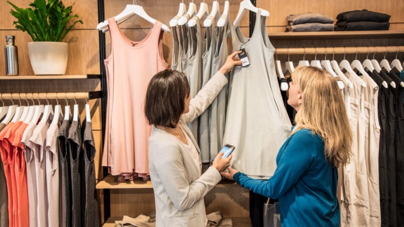 Two people in a store looking at clothing.