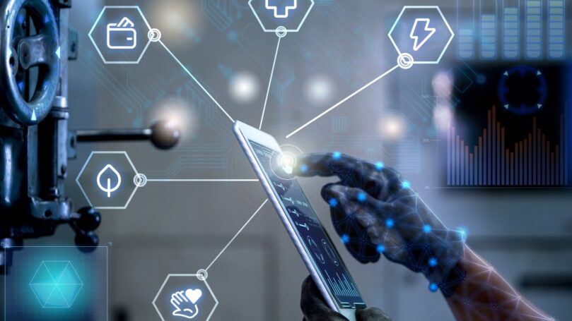 An abstract background of technology icons, network interfaces and board design frames an image of a hand interacting with a tablet, illustrating the connection points between industries and technology.