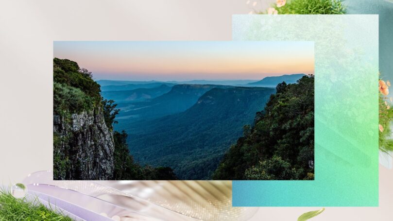 A serene landscape at sunset, showcasing a valley with lush green mountains on either side. The sky transitions from soft orange to blue, adding a tranquil ambiance. The foreground includes a textured, artistic collage with pastel colors and natural elements like grass and small flowers.