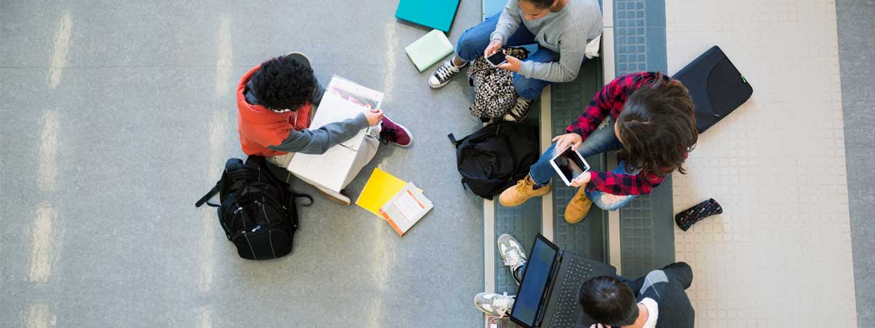 Four students sitting at a table studying and talking