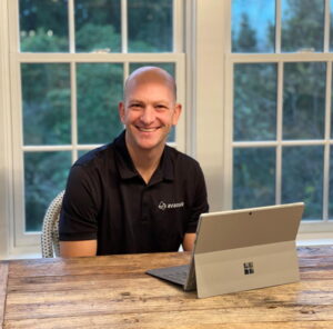Greg Kriegler smiles while he sits at his computer at home. 