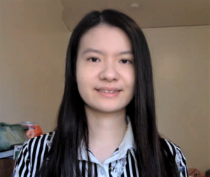 Lily Zhang smiles at the camera from a desk.