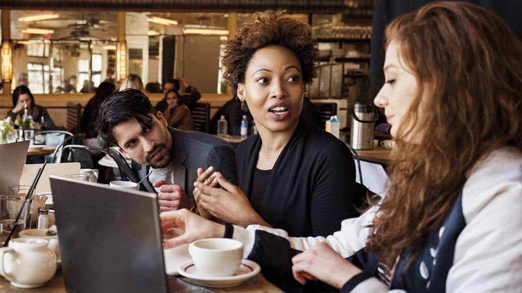 Young people in a café with a laptop and coffee.