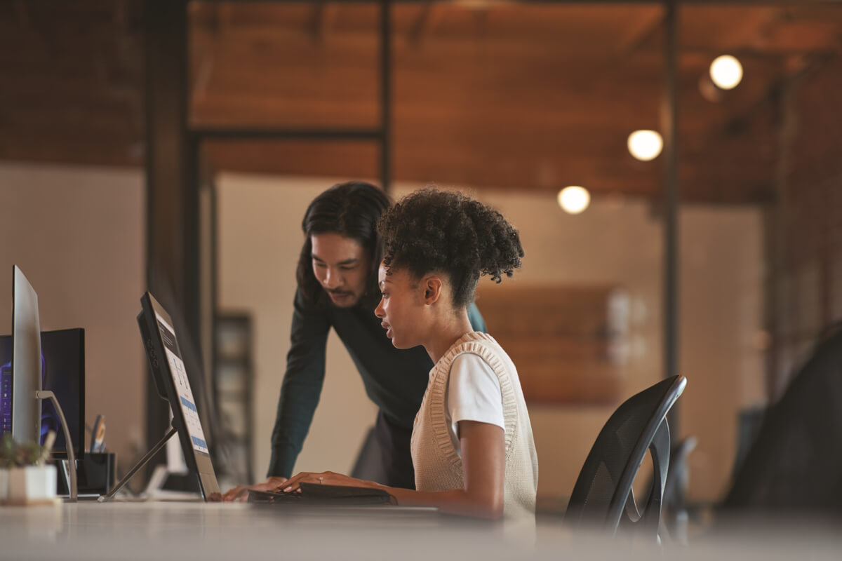 Two employees collaborate at a workstation in an open space in a Microsoft office.