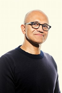 Nadella is shown smiling and gazing upward.