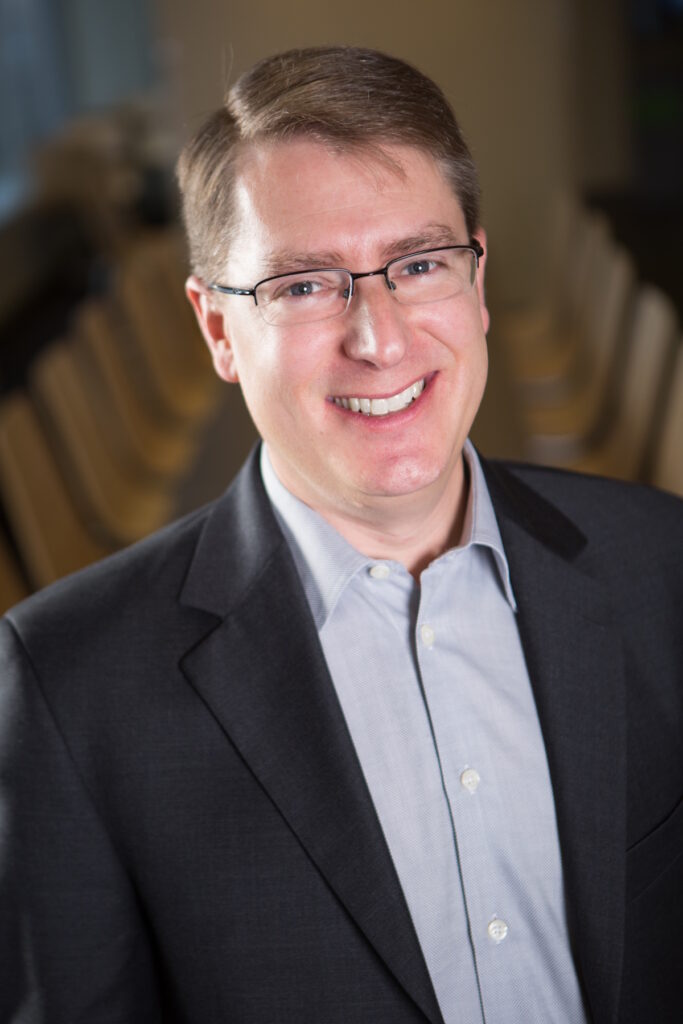 Osten smiles in a portrait photo.