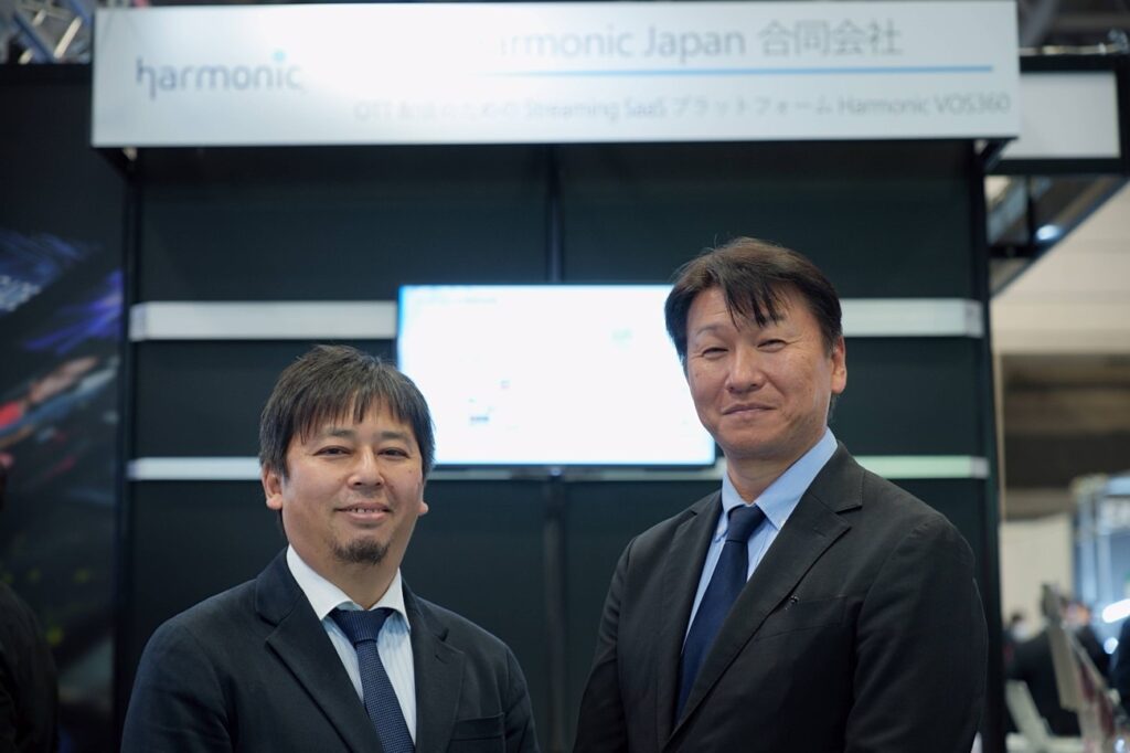 カメラに向かって微笑むスーツを着た二人の男性